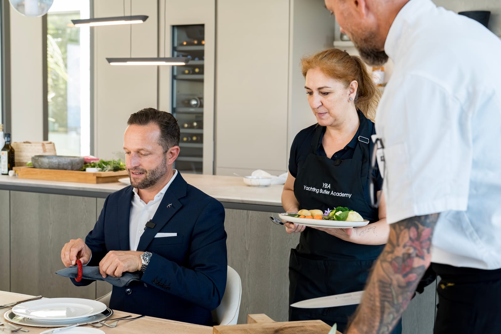 Server presenting a plated dish to a seated guest