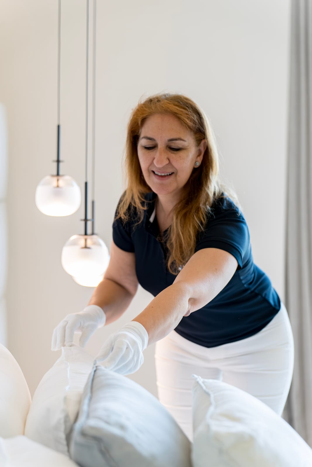 Housekeeperin macht ein Luxusbett während der Housekeeper-Ausbildung