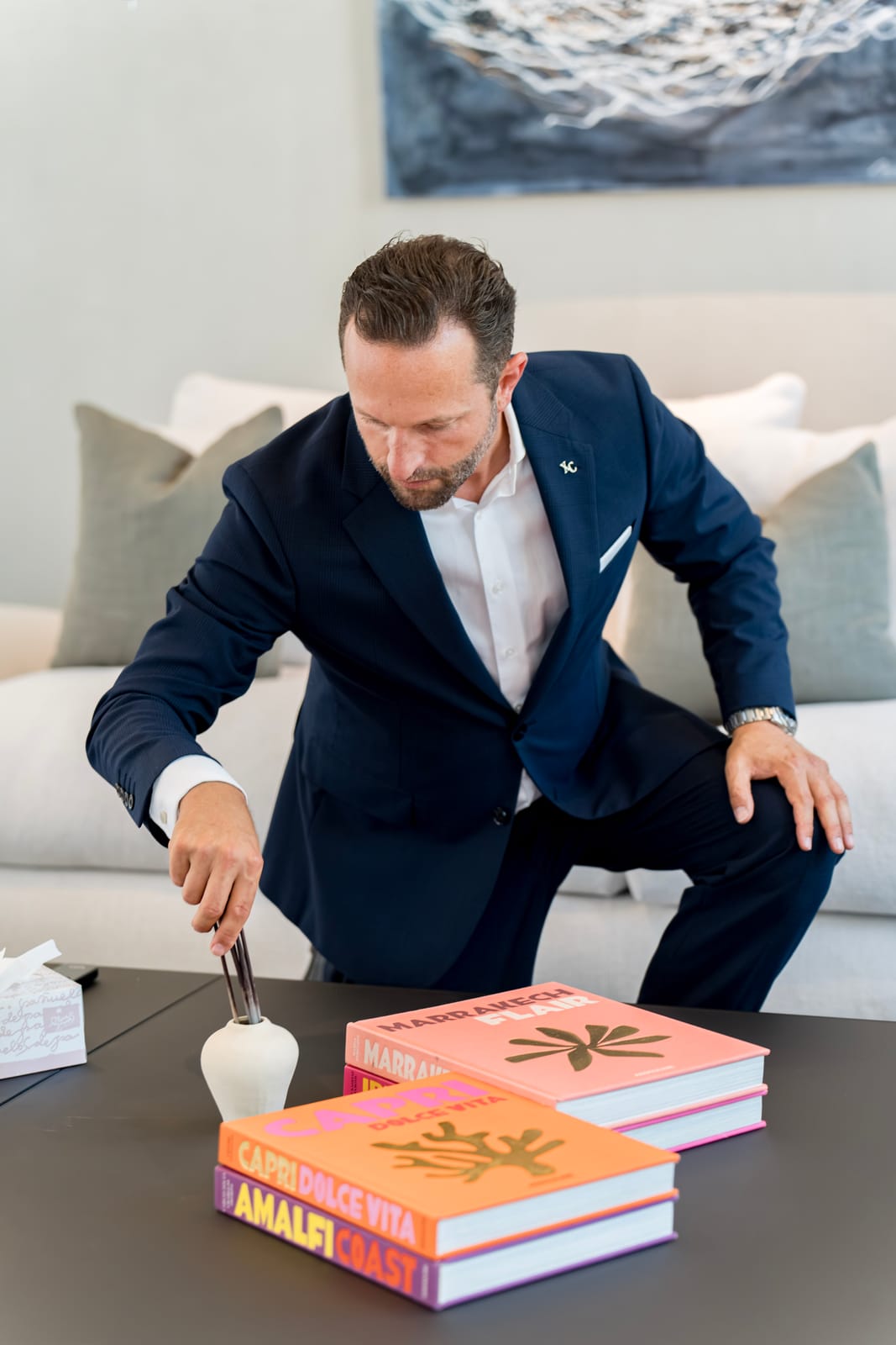 Butler lighting candles while styling a table for a dinner party