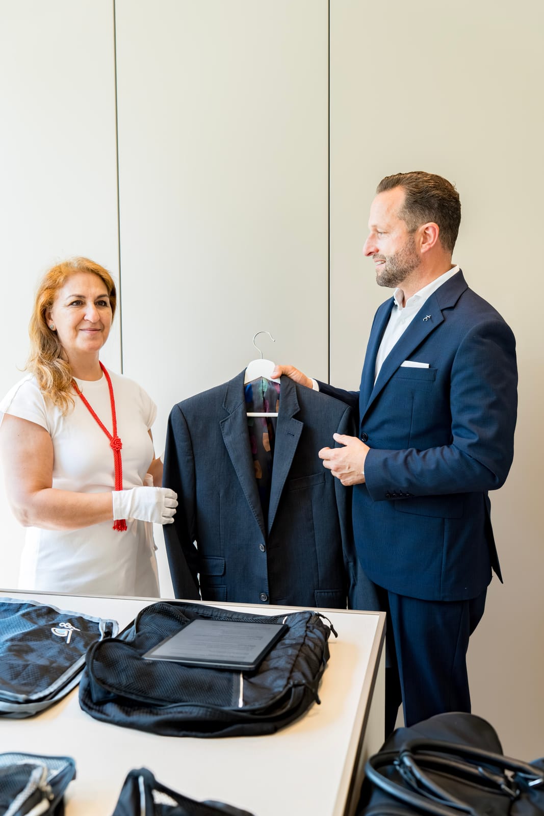 Butler and valet inspecting a tailored suit jacket
