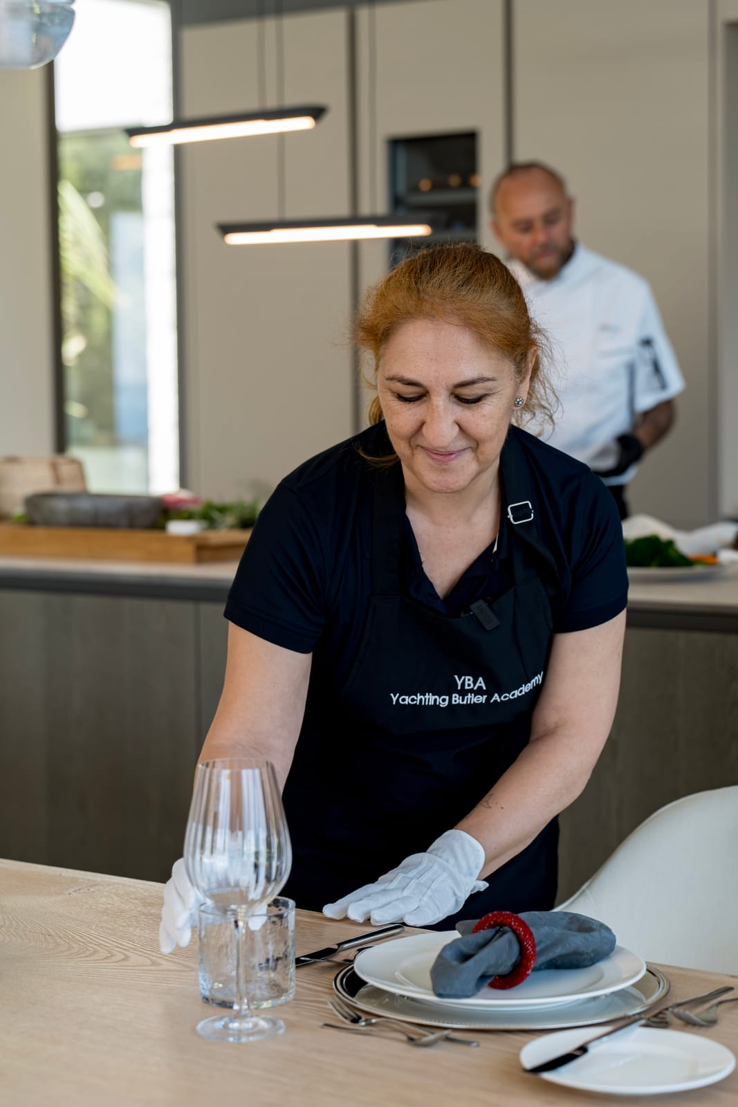 Yacht stewardess setting a table for fine onboard service