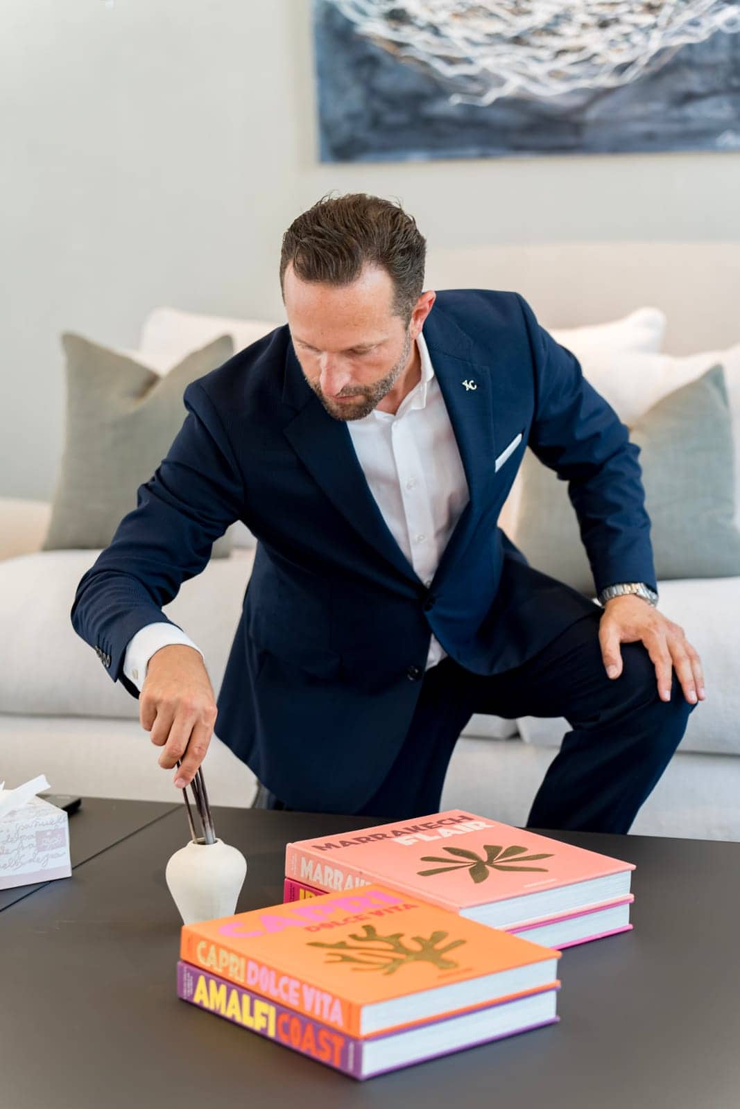 Butler lighting candles while styling a table for a dinner party